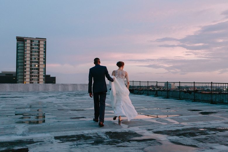Bride and groom on roof at sunset