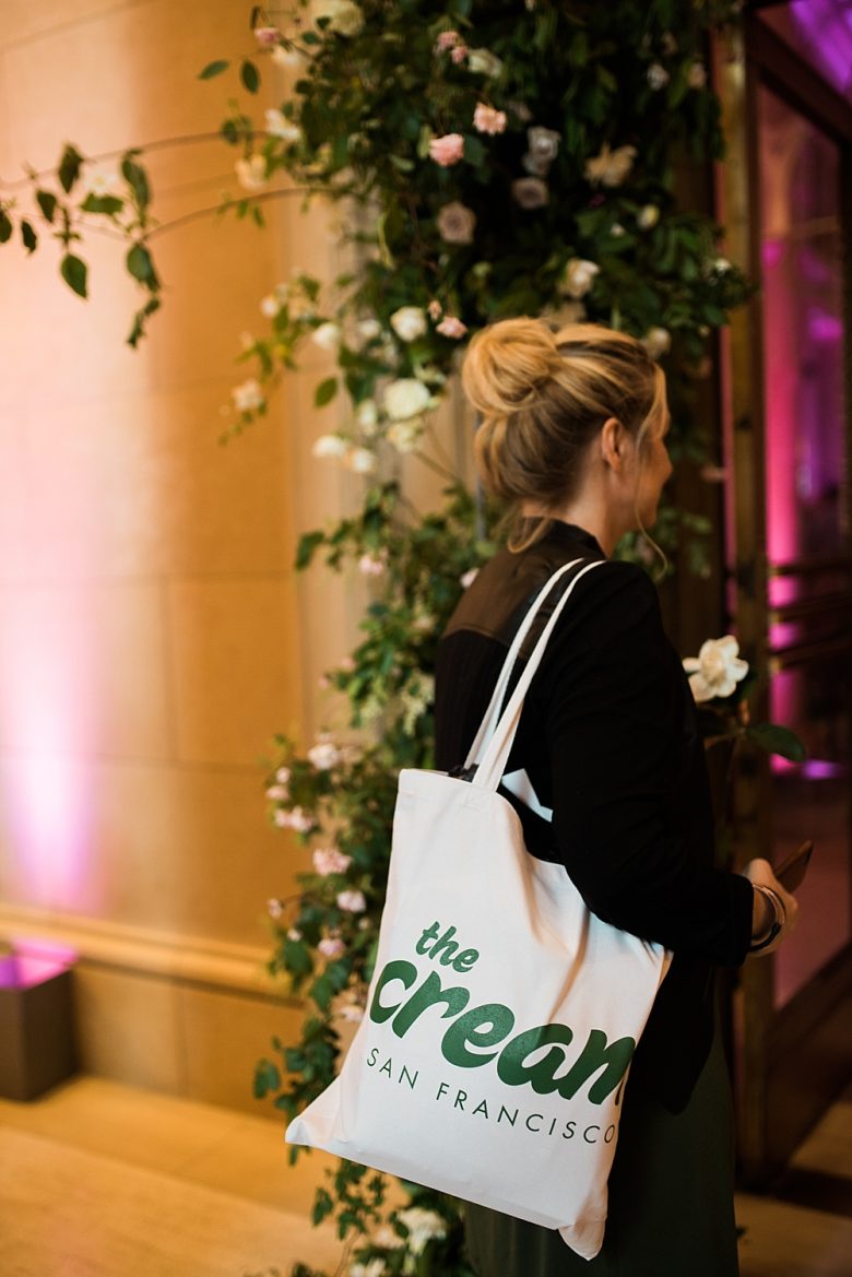 a woman walking into the cream event with a gift bag