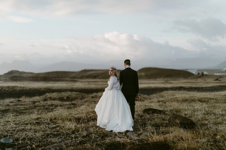 Bride and groom in field in Fjaðrárgljúfur