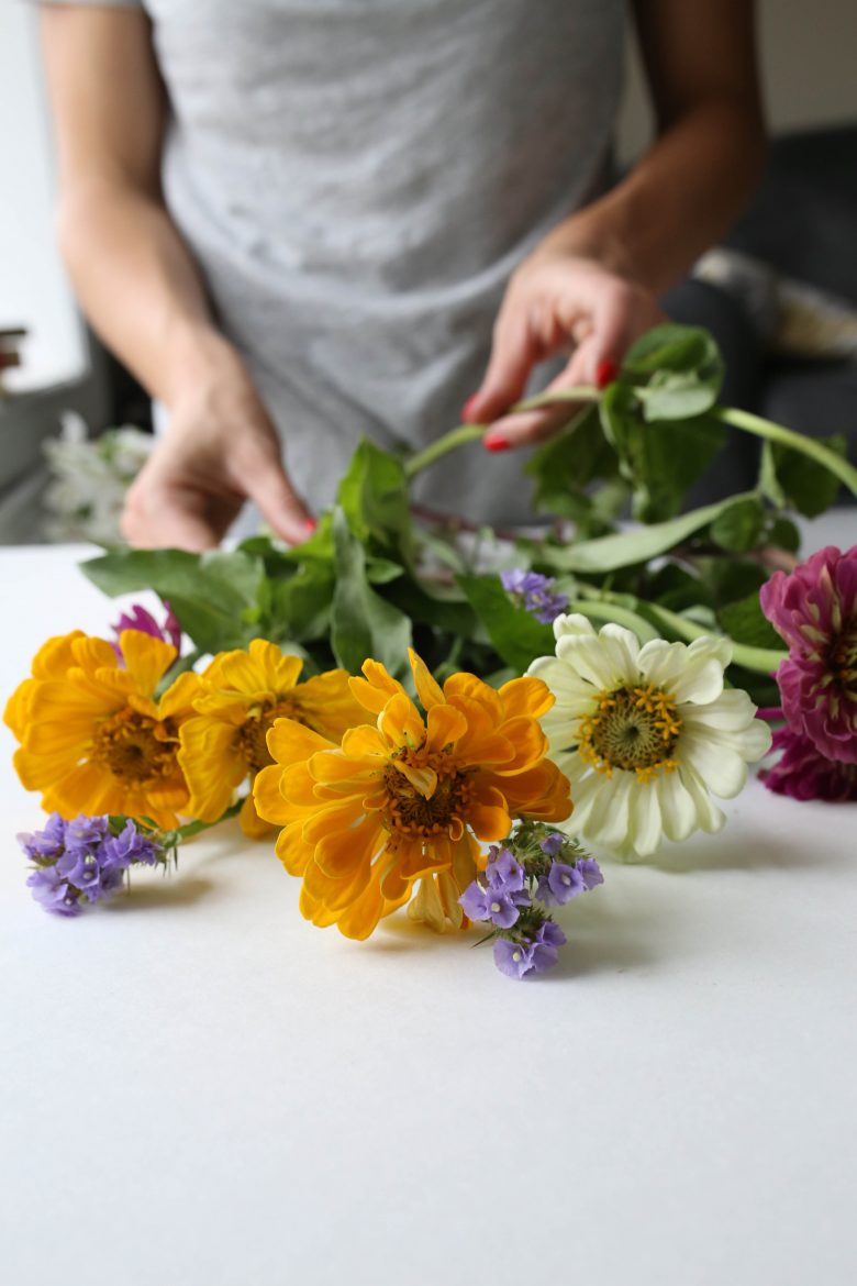 a woman putting together a flower bouquet