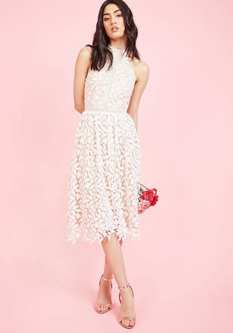 woman in sleeveless lace bridal shower dress on pink background
