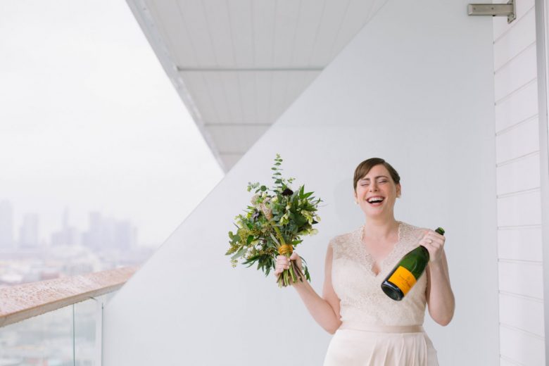Bride with bouquet and champagne by City Love Photography