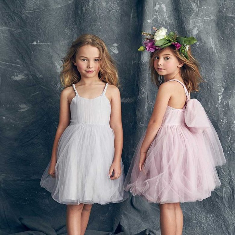 two little girls wearing modern tulle flower girl dresses