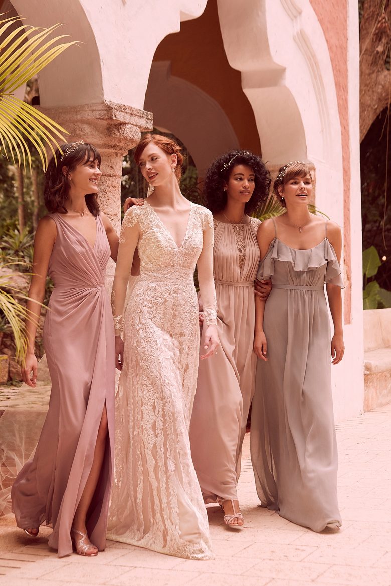 Woman wearing Linear Lace Wedding Dress, with three women in bridesmaid's dresses