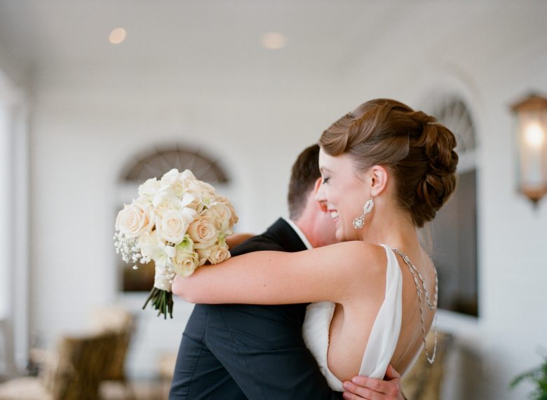 bride smiling with eyes closed embracing groom