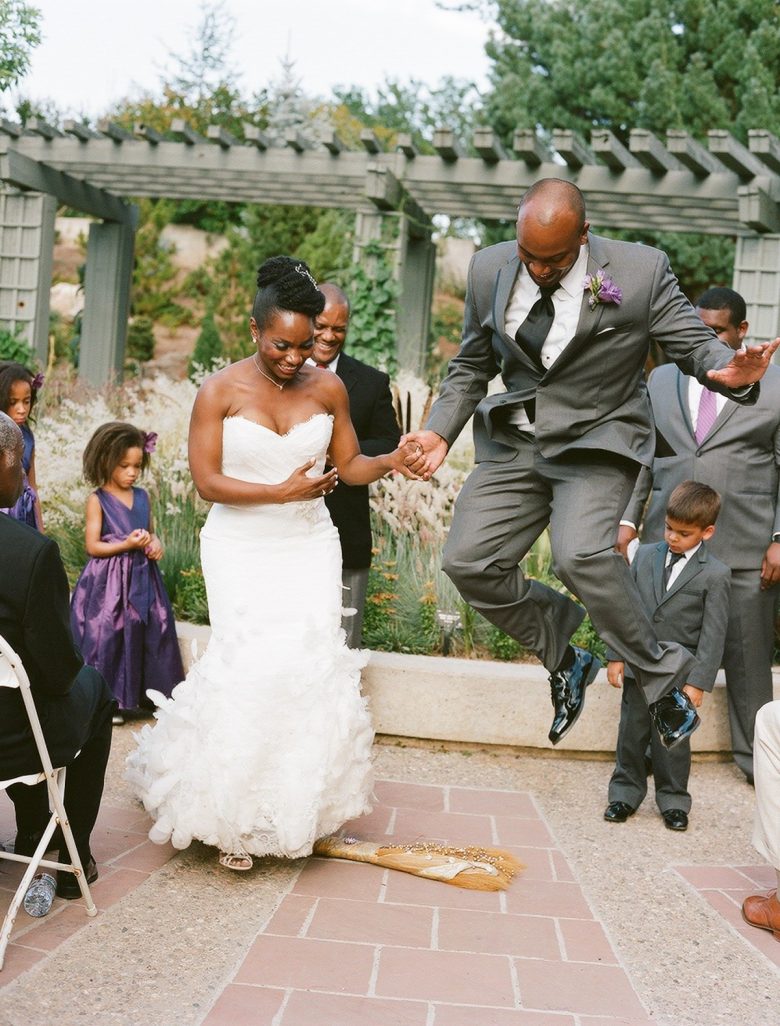 Bride and groom jumping the broom