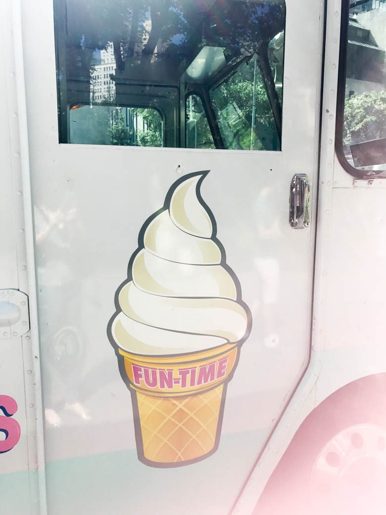 Door of ice cream truck that reads fun-time on a vanilla softserve cone