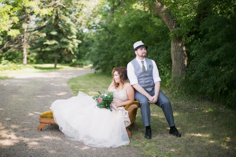 a wedding couple casually lounges on a couch at the side of a country road