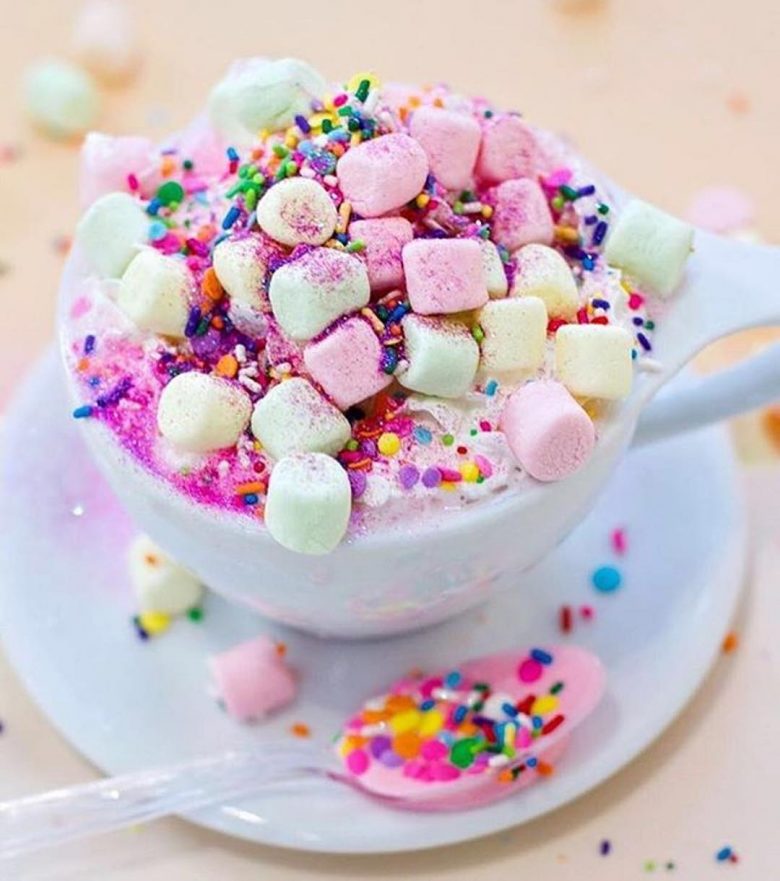 hot chocolate with rainbow sprinkles and pink, yellow, and green marshmallows