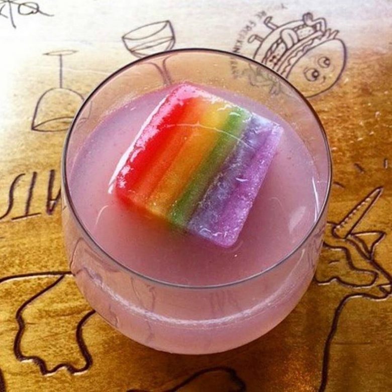 purple cocktail with rainbow ice cube