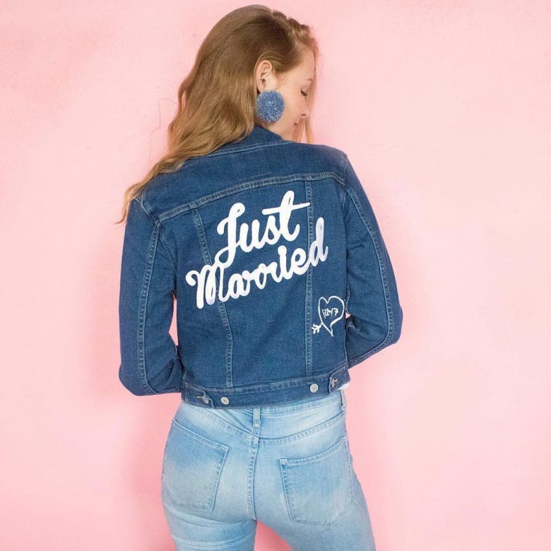 Woman wearing a denim jacked that says Just Married in white on the back