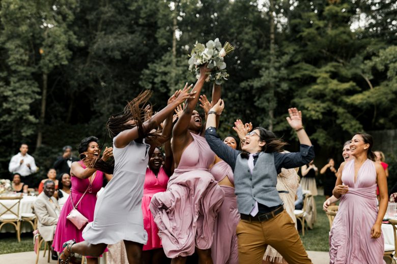 Group of people jumping for a thrown bouquet