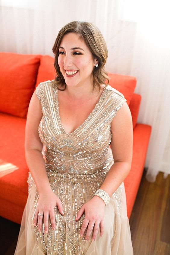woman in ’20s vintage-style gold beaded dress with shoulder length hair, side parted, in loose waves