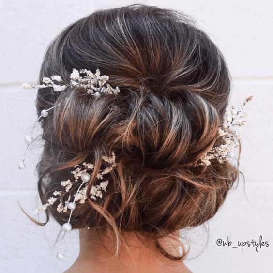woman's hair gathered into two loose horizontal rolls with floral and pearl accents