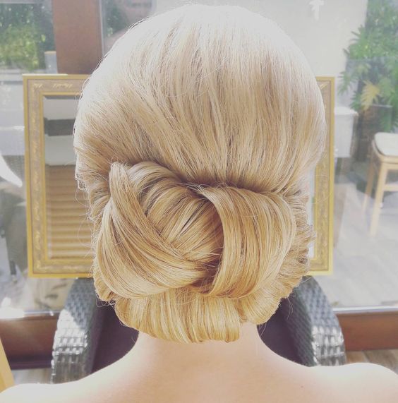 blond hair, sleeked back into a woven chignon for a wedding hairstyle