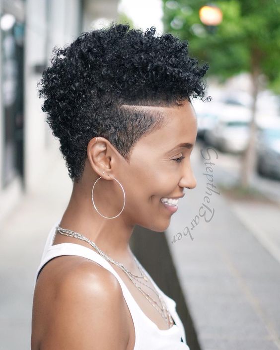 woman with fade on sides and long tightly curled hair on top 