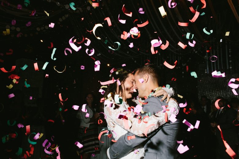 Couple embracing surrounded by colorful confetti