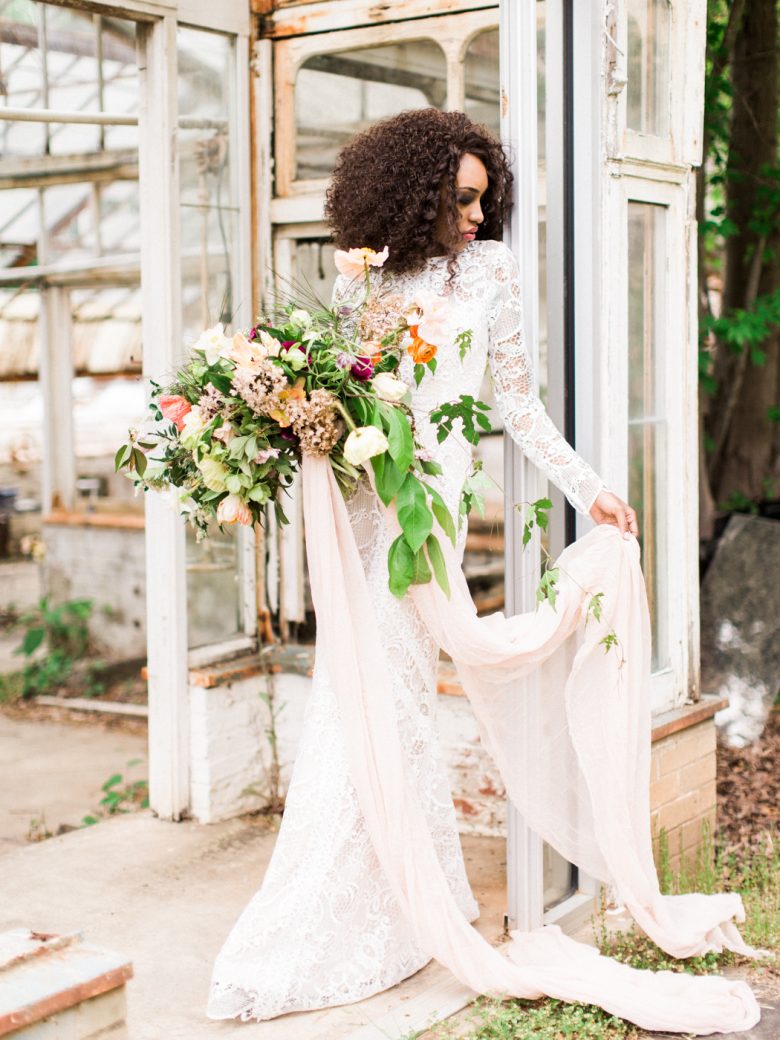 a bride stands elegantly in a doorway holding her bouquet