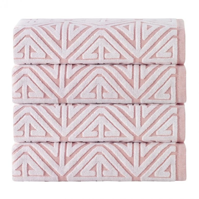 stack of millennial pink bath towels with white geometric raised pattern