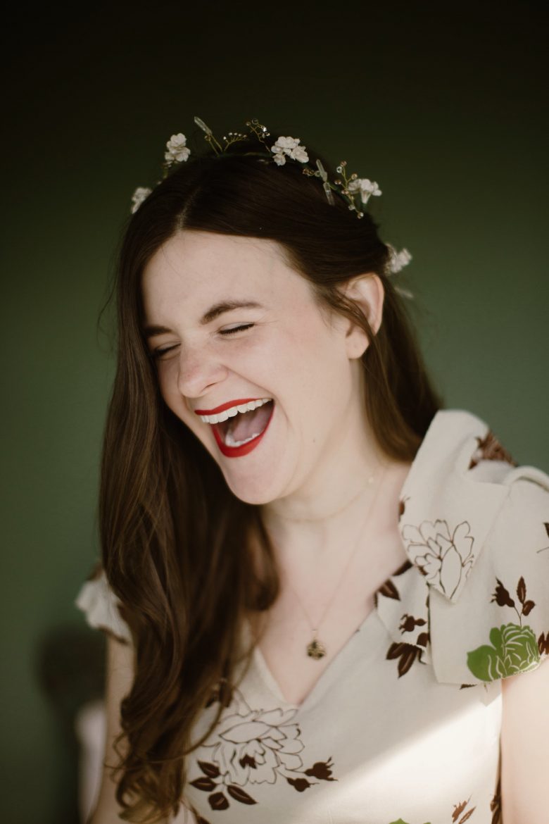 a bride smiles wide, caught mid laugh