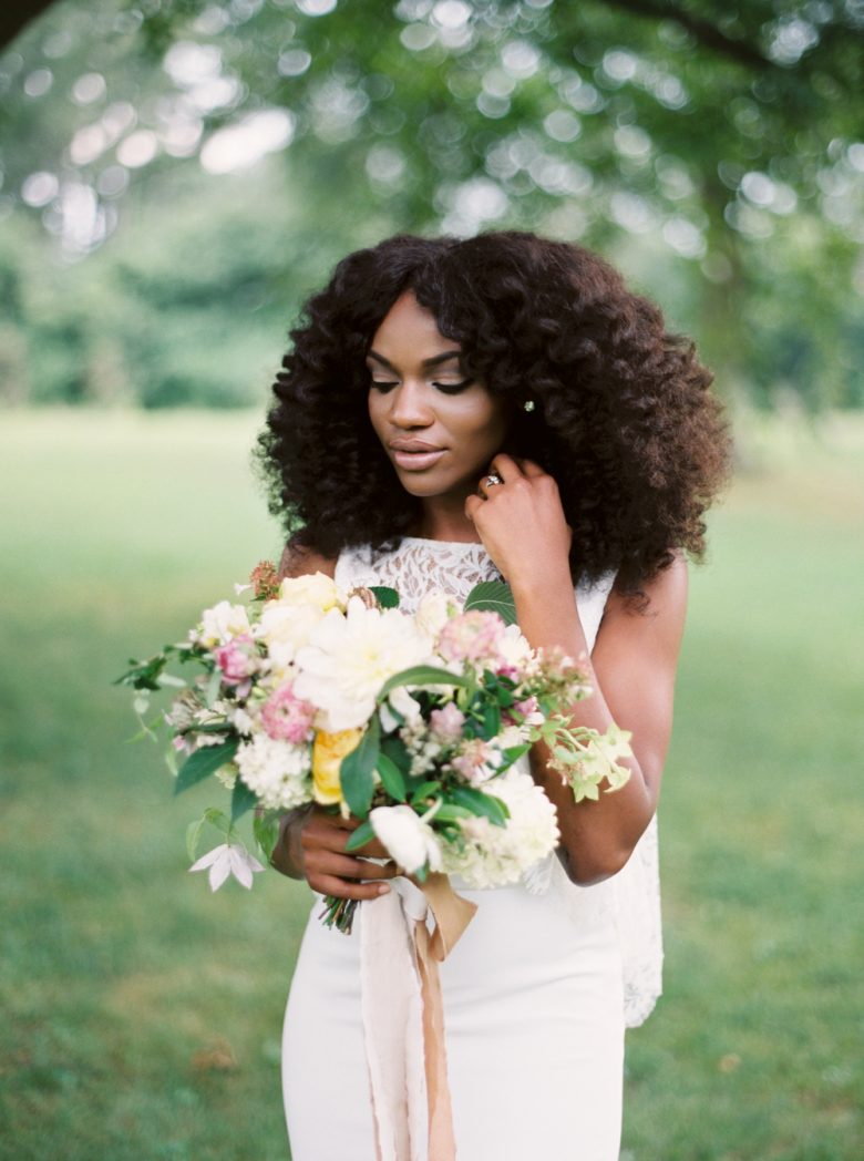 a black woman glances down at her bouquet during bohemian wedding