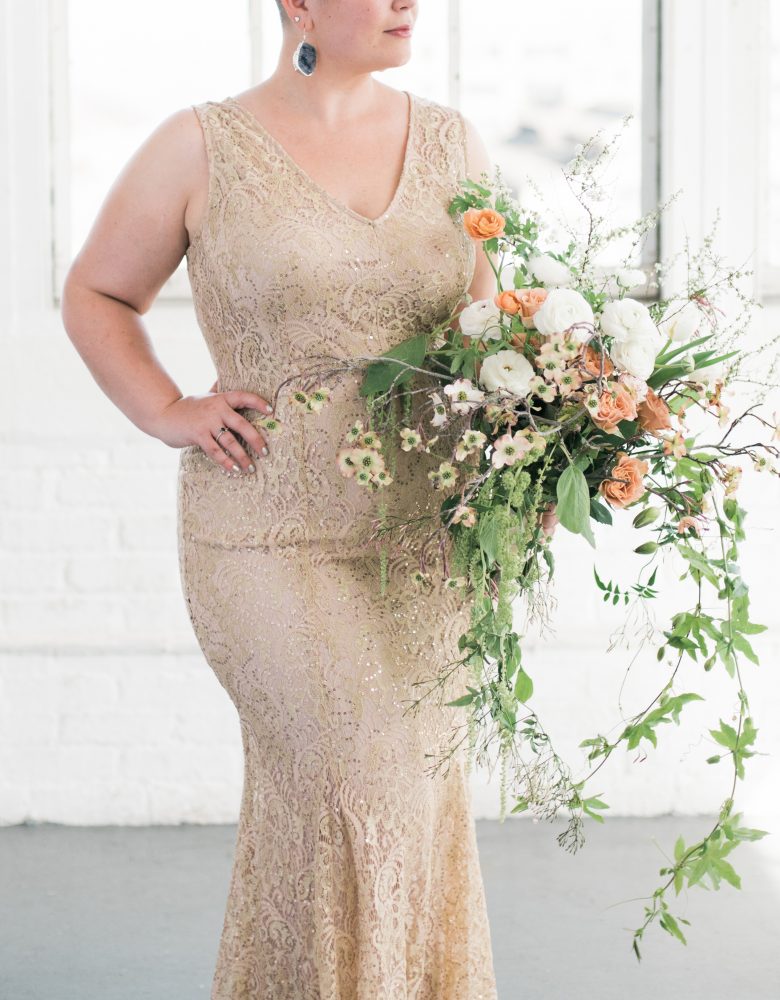 woman in champagne shimmery gown holds oversized bouquet