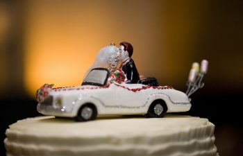 Photo of a caketopper of a wedding couple in a car