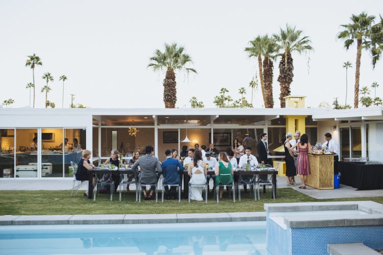 a large backyard dinner party next to the pool in Palm Springs