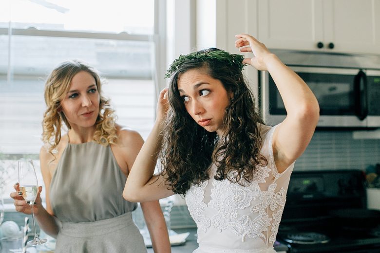 A bride putting on her green floral crown