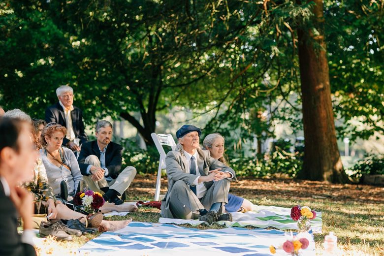 Guests at a wedding sitting on picnic blankets