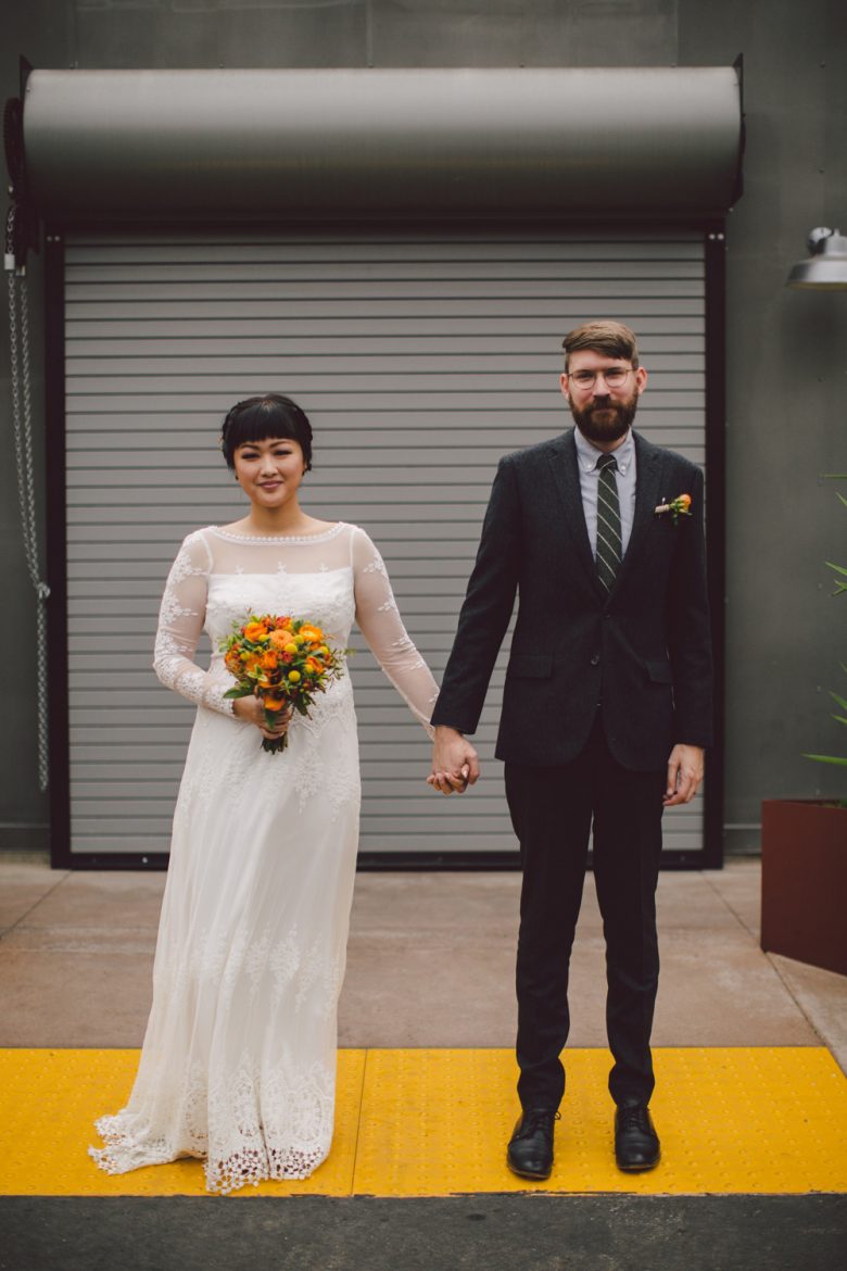 A wedding couple hold hands