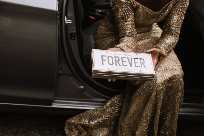 A bride holds a license plate that reads "Forever"