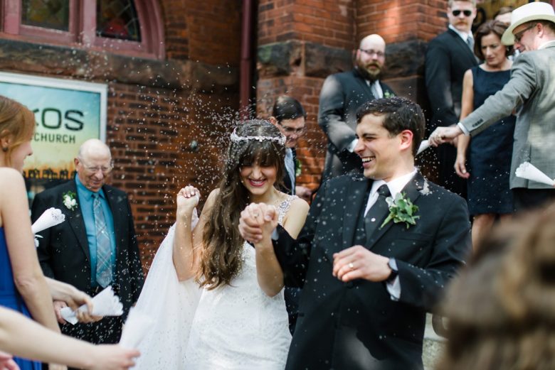 newly weds exiting, being showered in white confetti