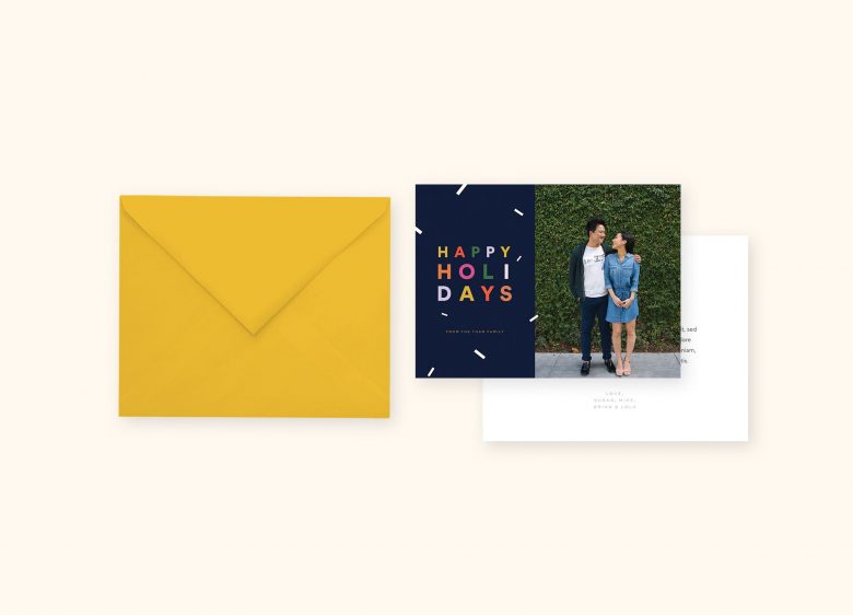 holiday card stationery suite with picture of couple gazing at each other in front of green ivy-covered wall
