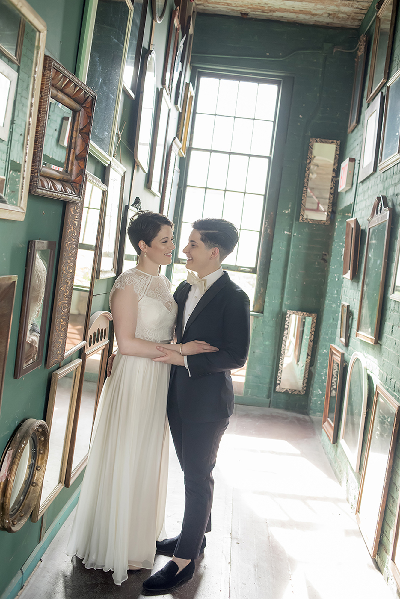 A wedding couple pose in a hall of mirrors 
