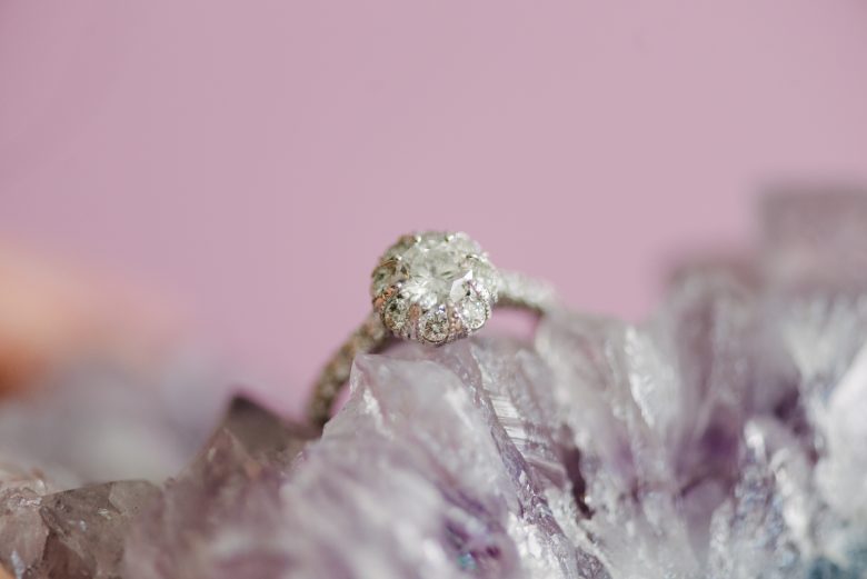 macy's star signature diamond engagement ring resting on a field of amethyst
