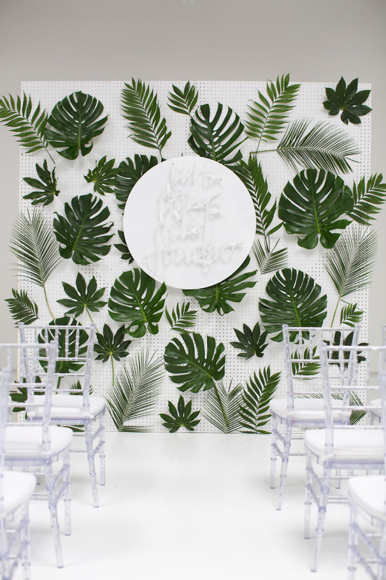 tropical leaf collage on white pegboard wall
