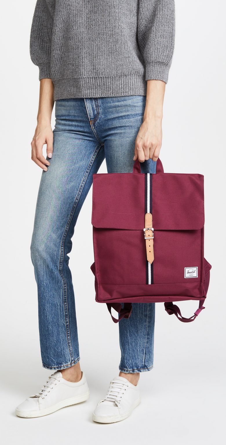 woman holding burgundy backpack