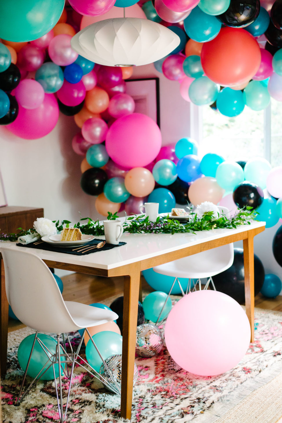table set with wedding cake in a room filled with a balloon installation