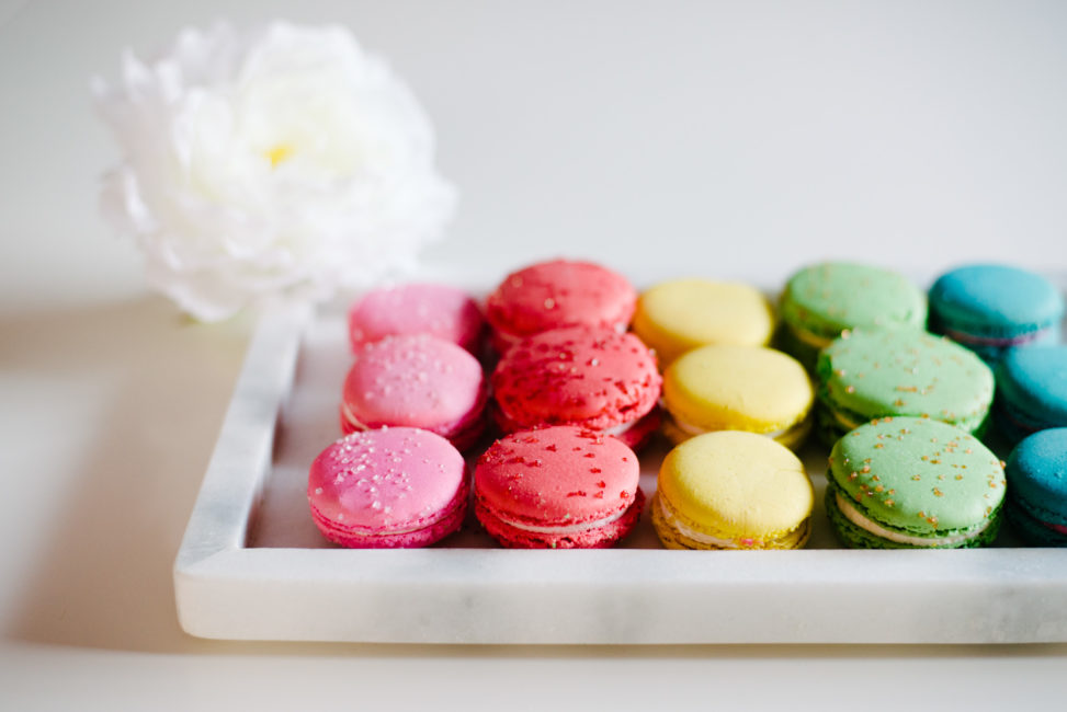crate and barrel white marble tray filled with rainbow macarons
