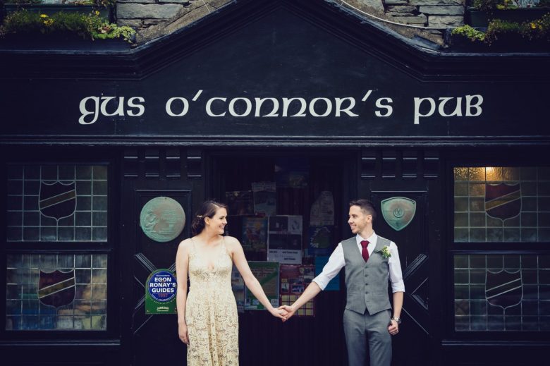 bride and groom holding hands in front of o'connor's pub