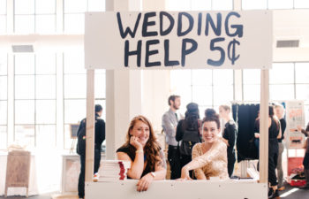 Two women in a "wedding help 5 cents" booth