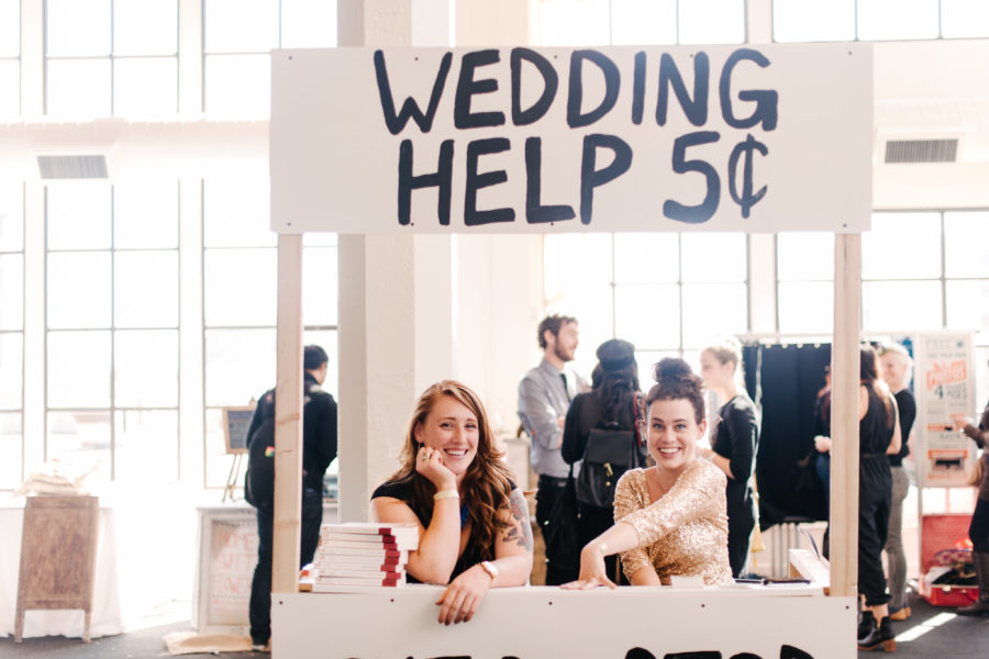 Two women in a "wedding help 5 cents" booth