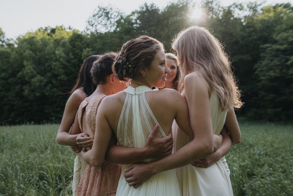 bride and bridesmaids embracing in a circle