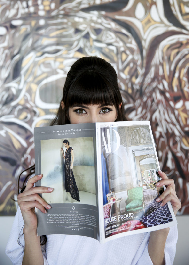 woman with bangs peeking over magazine