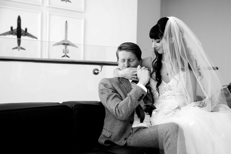 black and white photo of bride sitting on groom's lap