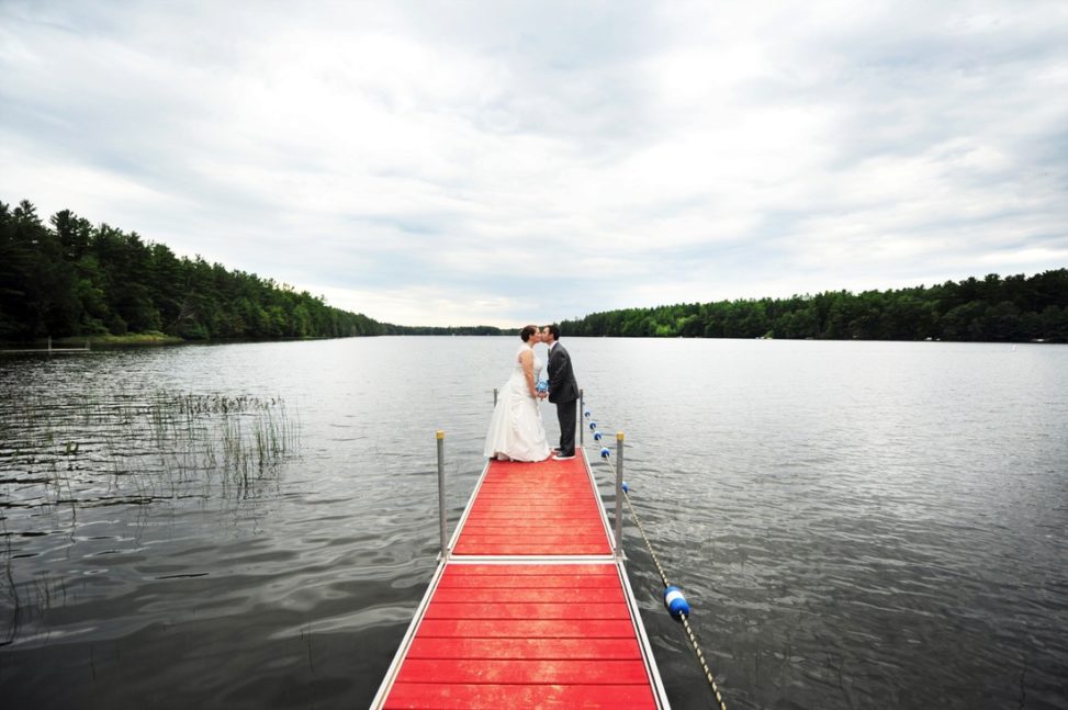 couple standing on the edge of a dock kissing