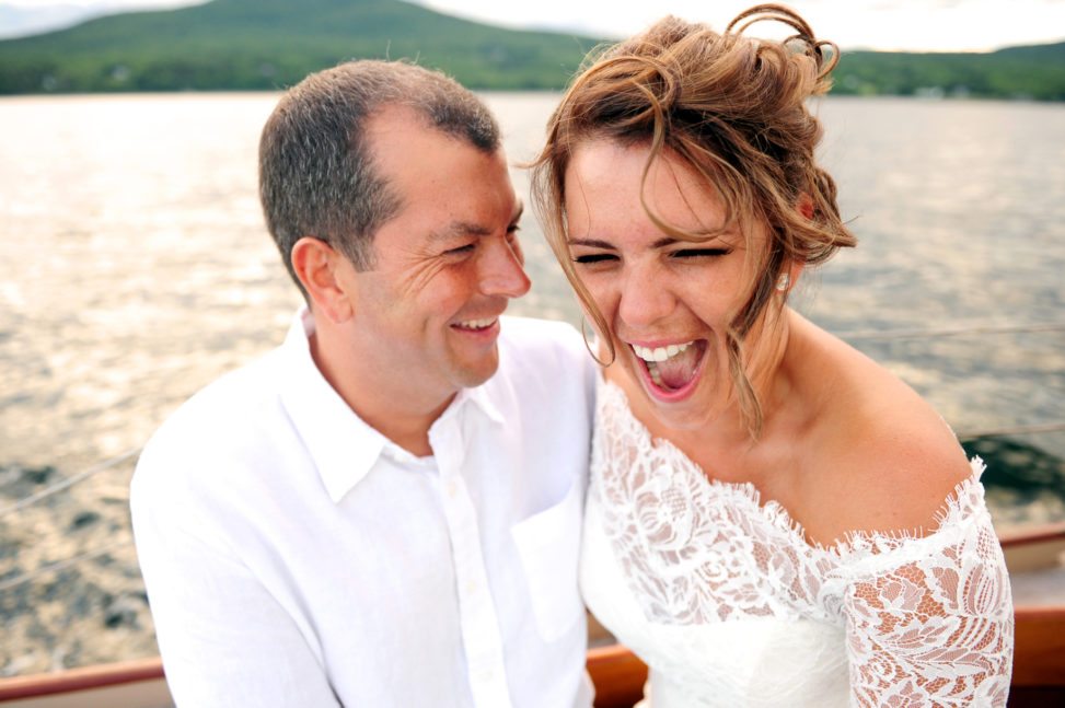 bride and groom on a boat, laughing