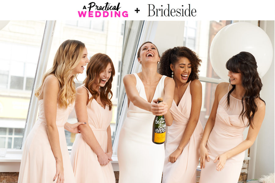 bride in white and bridesmaids in light pink dresses popping a bottle of champagne