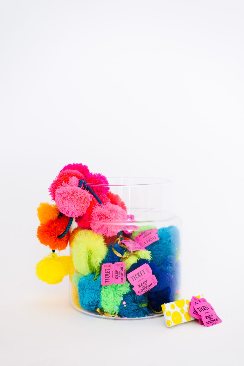 wedding party terrarium with pink and yellow mini pinatas and poof balls